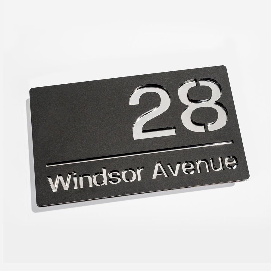 Modern matt black house sign with silver mirror – installed on brick wall