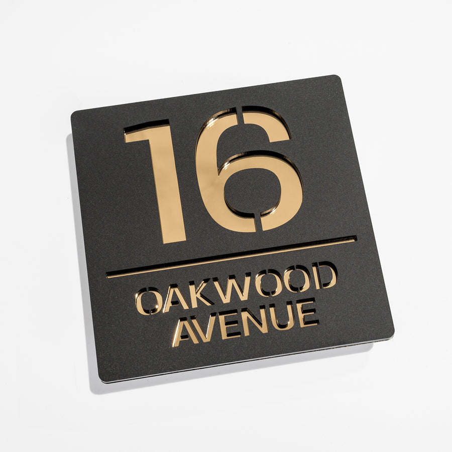 Matt black metallic house sign installed on rendered wall – gold mirror backing