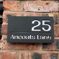 Modern matt black house sign installed on rendered wall – silver mirror finish