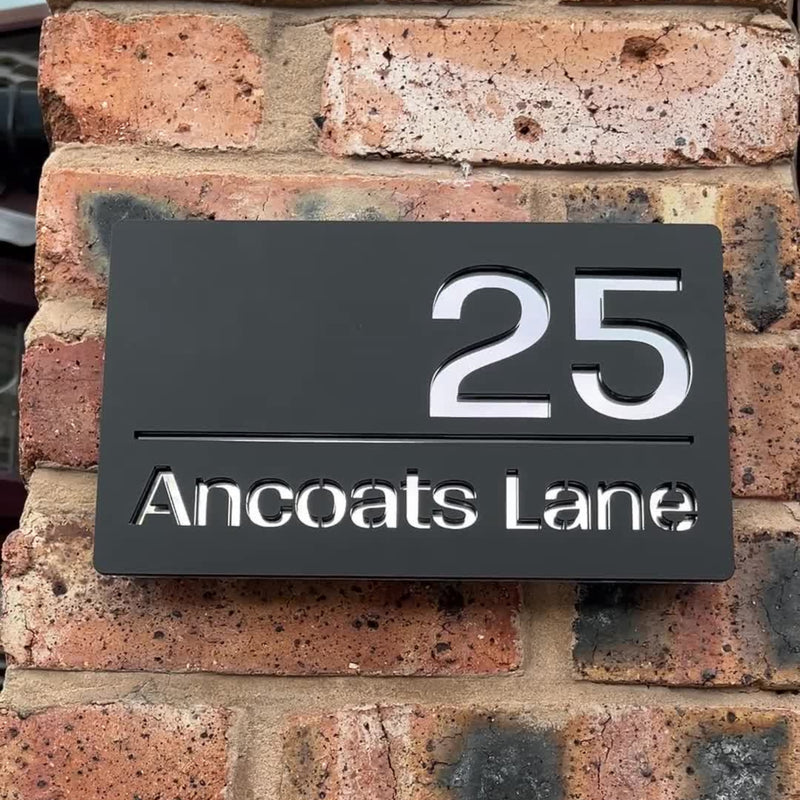 Matt black modern house sign installed on a new build exterior