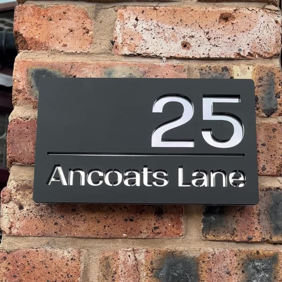 Modern matt black house sign installed on rendered wall – silver mirror finish