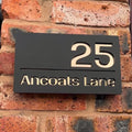 Modern matt black house sign installed on wall – gold mirror finish