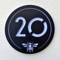 Close-up detail of the Manchester Bee House Sign showing the laser-cut bee emblem and translucent backing