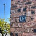 Matt grey stick on door number sign installed on brickwork – silver mirror finish