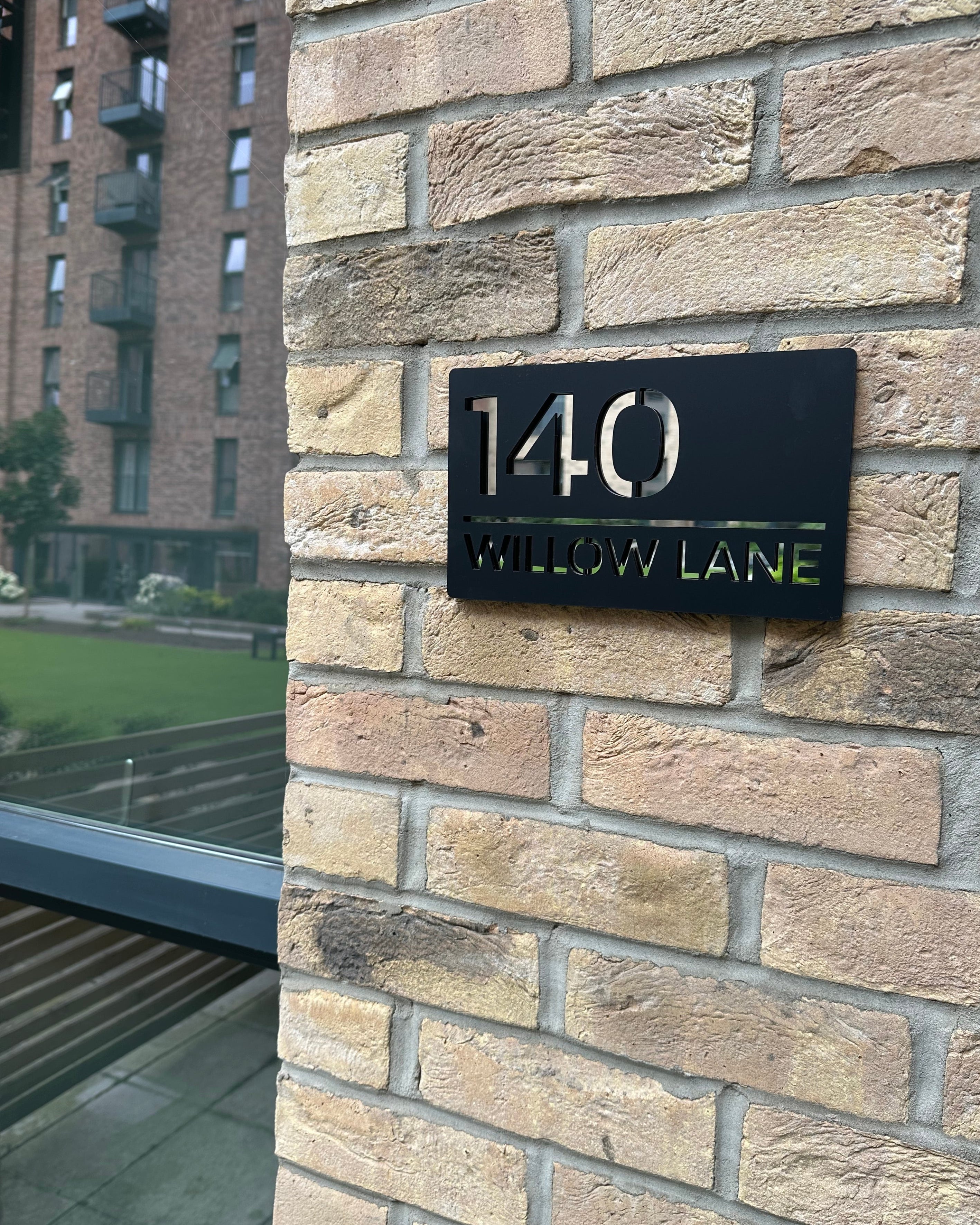 Address sign on a brick wall with building in the background