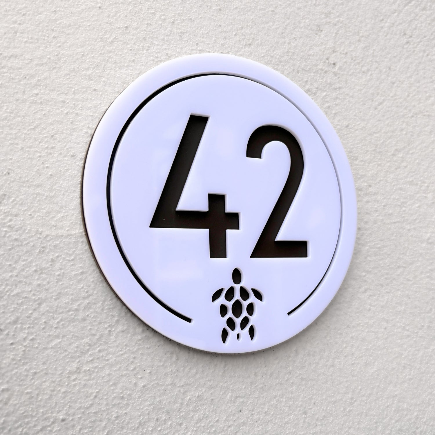 Close-up detail of the Turtle House Sign in white showing the laser-cut turtle motif