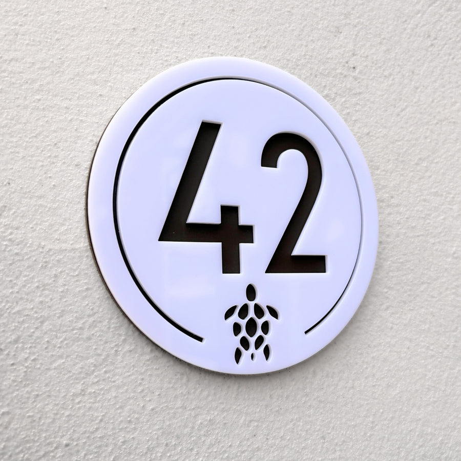 Close-up detail of the Turtle House Sign in white showing the laser-cut turtle motif